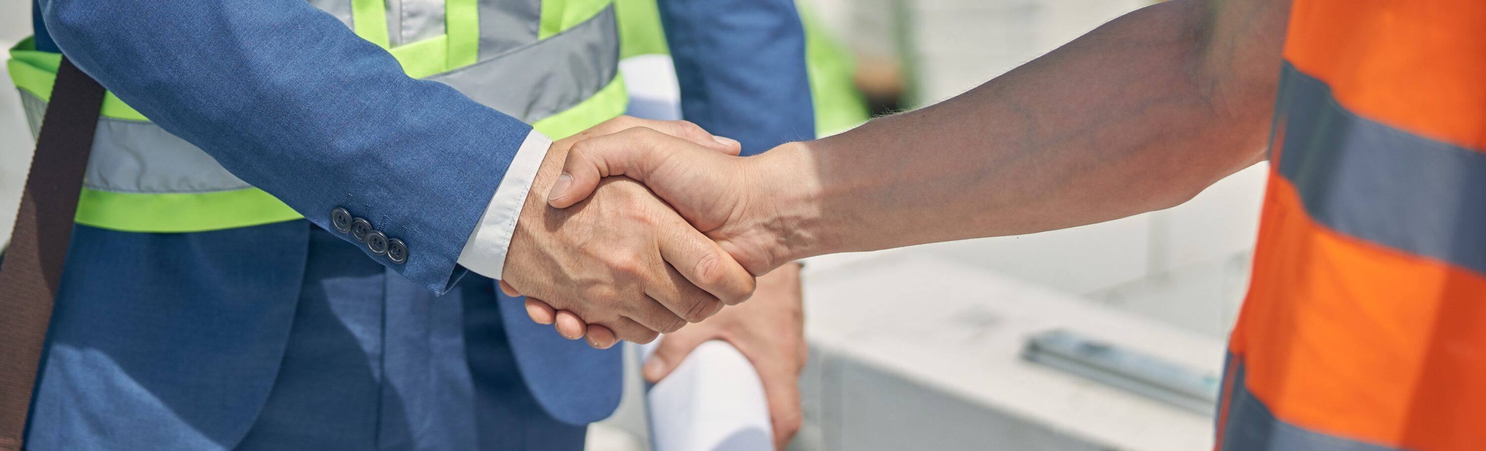 Civil engineer and male worker greeting one another